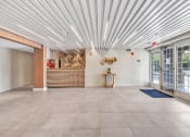 Thumbnail 28 of 37 - a lobby with a reception desk and glass doors at The Meriden, Meriden, CT 06450
