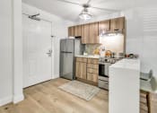 Thumbnail 24 of 37 - a kitchen with wooden cabinets and stainless steel appliances at The Meriden, Meriden Connecticut