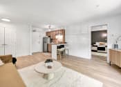 Thumbnail 22 of 37 - a wide shot of a living room and kitchen with plank wood floors and stainless steel appliances at The Meriden, Meriden, CT