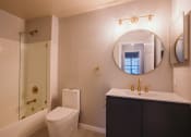 Thumbnail 2 of 22 - a bathroom with a toilet sink and a mirror at Ardenwood Apartments, North Haven, CT, 06473