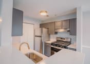 Thumbnail 11 of 22 - a kitchen with stainless steel appliances and a white counter top at Ardenwood Apartments, Connecticut, 06473