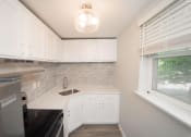 Thumbnail 7 of 19 - a small kitchen with white cabinets and a sink  at Enclave West Hartford / Parc West, West Hartford, CT, 06110