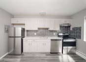 Thumbnail 29 of 39 - a kitchen with white cabinets and a stainless steel refrigerator at Encore 99, East Haven, CT, 06512