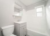 Thumbnail 6 of 39 - a white bathroom with a toilet and a tub at Encore 99, East Haven