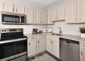 Thumbnail 23 of 39 - a kitchen with stainless steel appliances and white cabinets at Encore 99, East Haven, CT, 06512