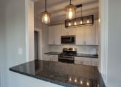 Thumbnail 42 of 55 - a kitchen with white cabinets and a counter top at The Packard, Connecticut