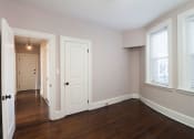 Thumbnail 35 of 55 - an empty living room with wood floors and a white door at The Packard, West Hartford, CT