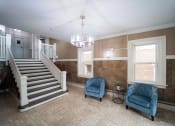 Thumbnail 15 of 55 - a living room with two blue chairs and a staircase at The Packard, West Hartford, CT