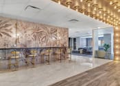 Thumbnail 11 of 41 - a lobby with a bar with chairs and a wall mural of palm trees at Up House, Farmington, CT, 06032