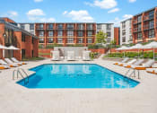 Thumbnail 23 of 41 - a pool with chairs and umbrellas in front of an apartment building at Up House, Connecticut