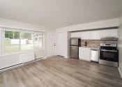 Thumbnail 19 of 33 - an empty kitchen with a large window and a stove and refrigerator at Woodbury, Connecticut