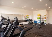 Thumbnail 4 of 23 - a gym with treadmills and other exercise equipment
