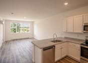 Thumbnail 7 of 23 - an empty kitchen with white cabinets and a sink
