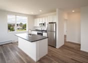Thumbnail 9 of 23 - a kitchen with a island and a stainless steel refrigerator