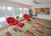 Thumbnail 12 of 14 - A room with red chairs and a painting on the wall.