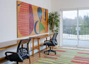 Thumbnail 11 of 14 - A room with a large painting on the wall and two chairs.