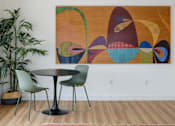 Thumbnail 10 of 14 - A large abstract painting hangs on a white wall above a round table with four chairs.