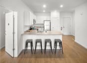 Thumbnail 13 of 32 - A kitchen with white cabinets and a white door.