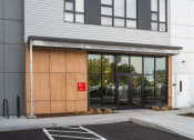 Thumbnail 32 of 41 - the entrance to a building with glass doors and a wood facade