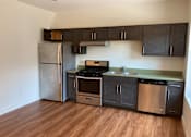Thumbnail 8 of 10 - A kitchen with a refrigerator, oven, and sink.