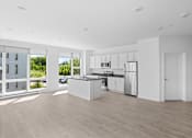 Thumbnail 24 of 30 - A modern kitchen with white appliances and cabinets.
