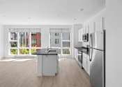 Thumbnail 21 of 30 - A modern kitchen with stainless steel appliances and a view of a building outside the window.