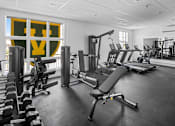 Thumbnail 1 of 10 - A gym with a variety of equipment including weights, benches, and treadmills.