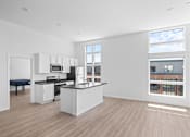 Thumbnail 30 of 30 - A kitchen with a large island and a view of the city.