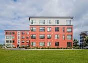 Thumbnail 42 of 42 - a brick building with a green lawn in front of it