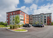 Thumbnail 41 of 42 - this is a picture of a parking lot with an apartment building in the background