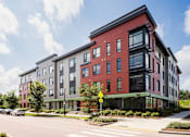 Thumbnail 39 of 42 - a red and grey apartment building on a street corner