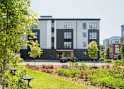 Thumbnail 2 of 30 - A modern building with a green lawn in front.