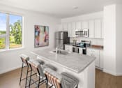 Thumbnail 11 of 30 - A kitchen with a bar area and a painting on the wall.