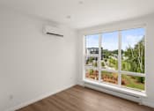 Thumbnail 18 of 30 - A room with a window overlooking a residential area.