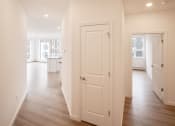 Thumbnail 15 of 41 - the living room and kitchen of a new home with white doors and wood flooring