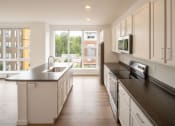 Thumbnail 14 of 41 - a large kitchen with black counter tops and white cabinets
