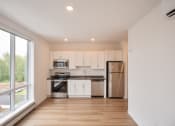 Thumbnail 20 of 41 - a kitchen with white cabinets and stainless steel appliances and a large window