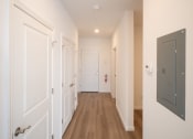 Thumbnail 21 of 41 - a hallway with white walls and wooden floors and a white door