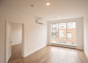 Thumbnail 17 of 41 - an empty living room with a large window and wooden floors