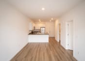 Thumbnail 16 of 41 - a living room and kitchen with white walls and wood floors