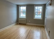 Thumbnail 20 of 24 - A room with wooden floors and two windows.