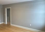 Thumbnail 22 of 24 - A room with a wooden floor and a white door.