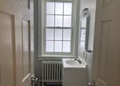 Thumbnail 13 of 24 - A white sink in a small bathroom with a window.