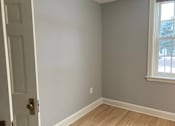 Thumbnail 21 of 24 - A room with a white door and a window.