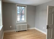 Thumbnail 18 of 24 - A room with a window and a radiator on the floor.