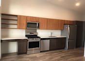 Thumbnail 16 of 18 - A modern kitchen with a stainless steel refrigerator, oven, and microwave.