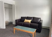 Thumbnail 12 of 15 - a living room with a couch and a coffee table
