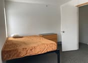 Thumbnail 14 of 15 - a small bedroom with a bed and a dresser