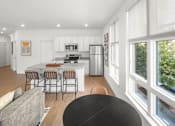 Thumbnail 13 of 30 - A modern kitchen with a dining table and chairs.