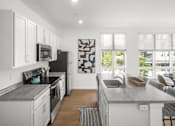 Thumbnail 7 of 30 - A modern kitchen with a black and white artwork on the wall.
